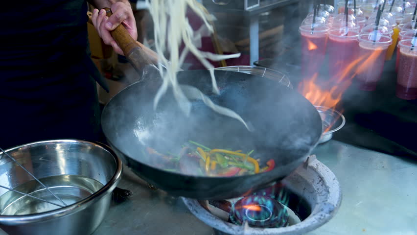 Chef prepares Asian dish in a frying pan