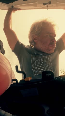 Funny worried man opens hood of his broken car. Unprofessional person or problem concept, vertical video