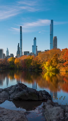 Early morning on Central Park Lake in Autumn colors with view of New York City Billionaire