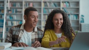 Two students friends classmates African American man Latina Caucasian woman laptop desktop computer high five achievement together smile hug success victory win teamwork technology library university - Powered by Shutterstock - Get 15% off with code: PIKWIZARD15