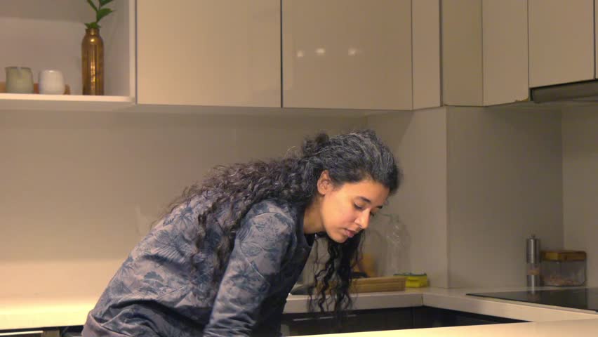 MUJER LATINA RECOGIENDO LA COCINA