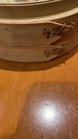 Xiao Long Bao soup dumplings siting in a wooden steamer from Din Tai Fung. 