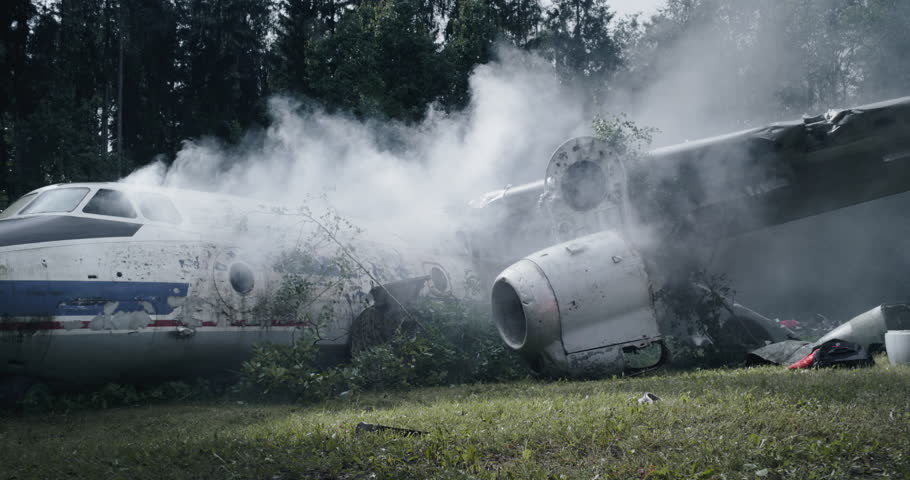 Remote Forest Airplane Crash. Crashed Airliner Lies in Ruins. Aircraft is Shattered with Pieces Scattered Across the Ground and Smoke Billowing From the Wreckage