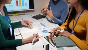 Asian businesspeople team analyzing and brainstorming using calculators. Hands pointing financial data on the sheet. Graph Chart showing earnings. growth teamwork process concept. - Powered by Shutterstock - Get 15% off with code: PIKWIZARD15