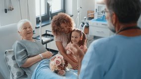 A family visiting senior 80s woman grandmother in the hospital. A little cute girl and her mid-adult mother are talking to a doctor while during visit in the ward - Powered by Shutterstock - Get 15% off with code: PIKWIZARD15