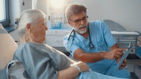 Elderly male doctor using digital tablet talking to senior woman patient at hospital, senior doctor showing results on tablet to old female patient in hospital ward - Powered by Shutterstock - Get 15% off with code: PIKWIZARD15