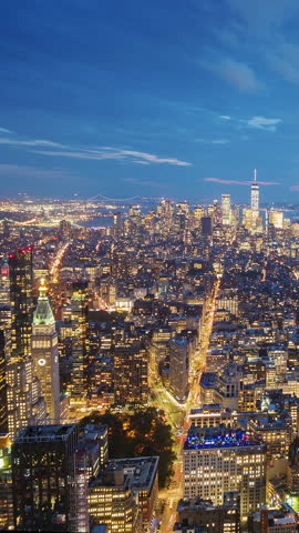 Manhattan transitioning from day to night, with the bustling energy of New York City coming alive as traffic intensifies and the skyline lights up.. Vertical video
