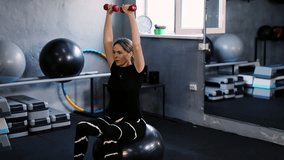 Workout. Fit, Gym sports workout in GYM. Motivation, wellness. A woman is engaged in fitness, doing stretching and physical exercises with dumbbells in the gym. Health, fitness, eco fit. - Powered by Shutterstock - Get 15% off with code: PIKWIZARD15