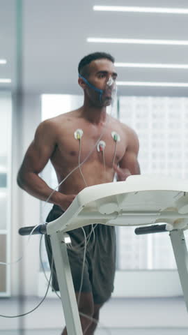 Vertical Screen. Athletic Individual Wearing Headset for Advanced Cardiopulmonary Testing on High-tech Treadmill. Subject Wears Oxygen Mask and Ecg Electrodes, Highlighting Sports Science