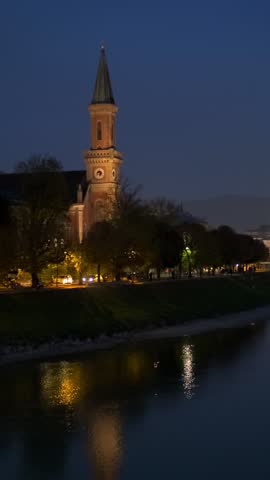 Salzburg city night view. Cathedral, Old Town Altstadt, church, Hohensalzburg, castle illuminated with lights. Salzach River waterfront with promenade. Salzburg, Austria