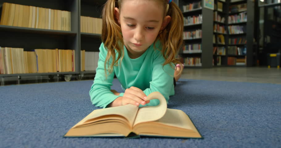 Animation of school items icons over caucasian schoolgirl reading book in library. Global education, school, science and digital interface concept digitally generated video.