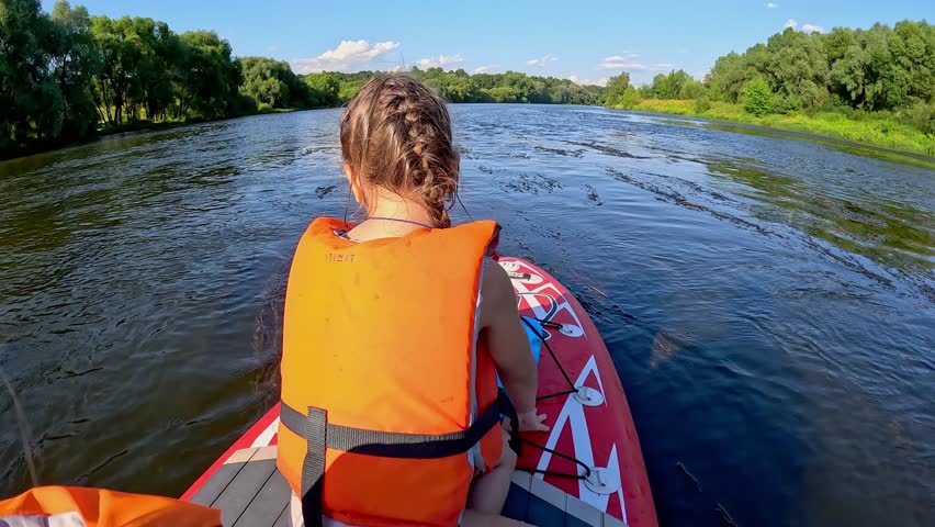 The video showcases a day of adventure twins sisters on a serene river on sup 