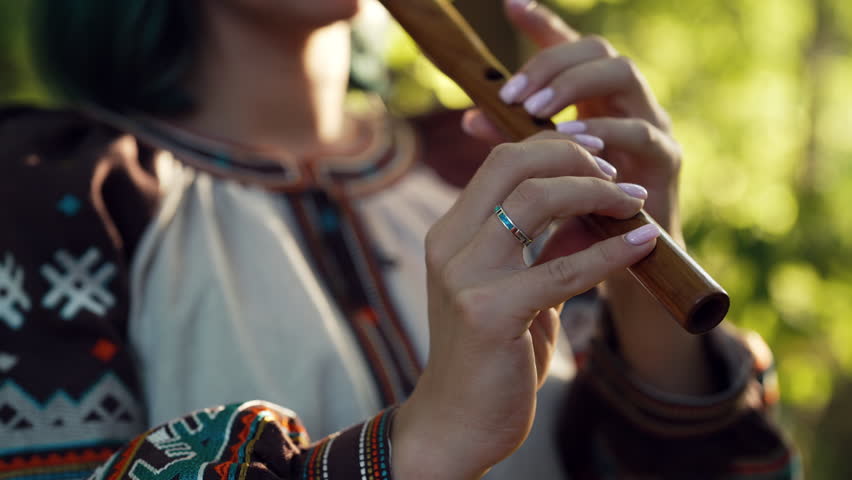 Hand Of Woman Playing On Woodwind Flute - Ukrainian Wooden Sopilka in Forest. Folk music concept. Musical instrument. Lady in traditional embroidered shirt - Vyshyvanka