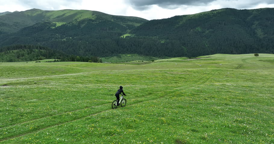 Aerial footage of woman riding mountain bike on beautiful forest mountain trail
