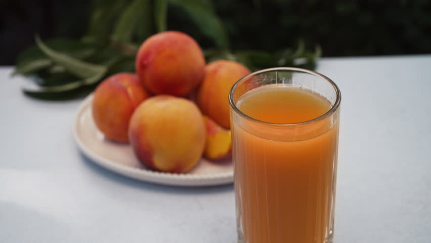 Appetizing Footage Of Ripe Peaches On Table With Glass Of Freshly Squeezed Juice