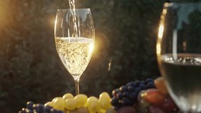 Stunning view of pouring white wine into glass goblet with fresh grape bunch background, sun light breaks through vineyard.  - Powered by Shutterstock - Get 15% off with code: PIKWIZARD15