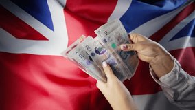 UK flag background. Woman counting GBP money pounds sterling. Credits, raising tariffs in Great Britain, traveling costs, financial concept. - Powered by Shutterstock - Get 15% off with code: PIKWIZARD15