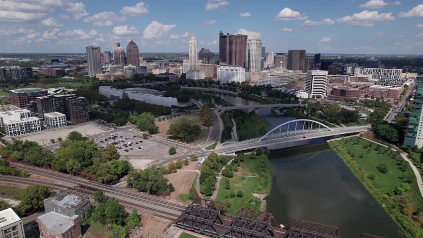 Drone aerial of cityscape, buildings, skyscrapers, and high-rises of capital city of Columbus, Ohio in United States, with new Peninsula and Franklinton construction and homes in the foreground