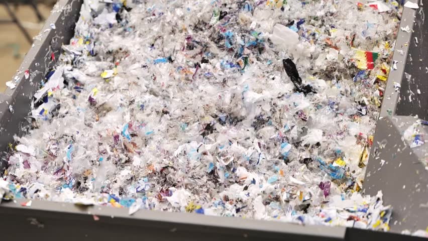 A close-up of shredded paper materials being processed in a recycling facility highlights the importance of waste management and recycling practices