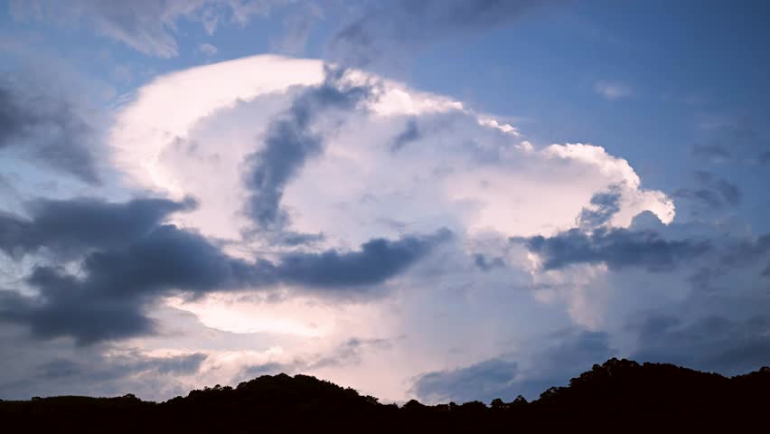 At dusk. Gentle waves lap against smooth, rounded rocks in a tranquil cove. The sky is painted in soft hues of pink and purple, reflecting on the calm water. Suao, Yilan, Taiwan.