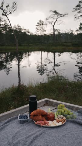 Morning picnic near a beautiful lake on the bog. Relaxing outdoor picnic setup early in the morning