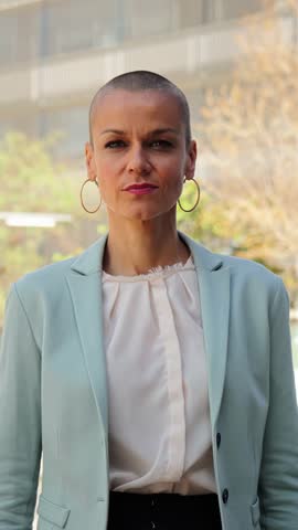 Vertical. business woman standing arms crossed at workplace looking at camera. Corporate female or employee folded outside of the office with proud attitude. Front view of ceo lady with blazer jacket