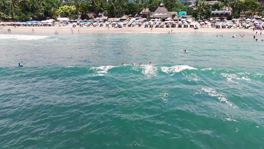 Two Surfers Ride the Wave in Sayulita, Mexico
