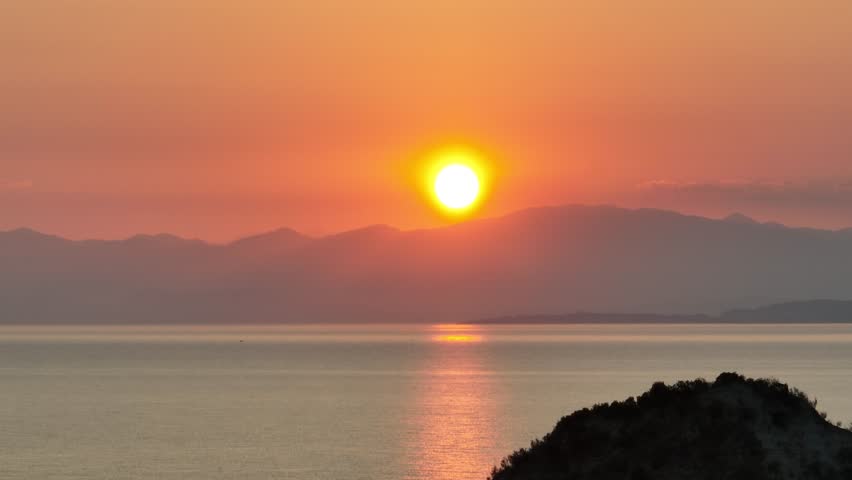 4K scenic red sunrise background sun rising. Close up video of sun rising behing seain corfu Greece