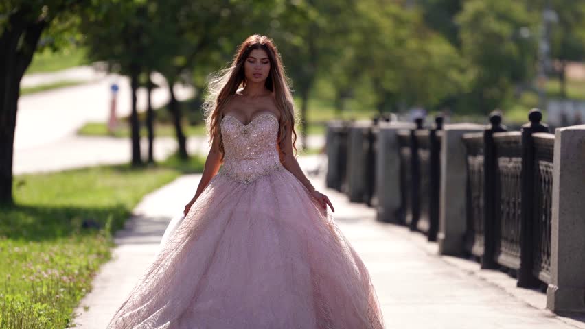 A woman in an exquisite dress walks around the city, her outfit shimmers in the sun, creating a magical feeling of a fairy tale and a dream.