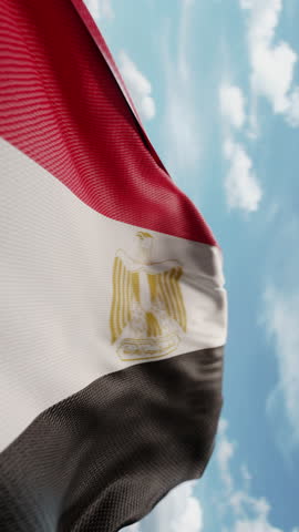 Wavy flag of Egypt blowing in the wind in slow motion. Waving colorful Egyptian flag team symbol abstract vertical background. Blue sky with clouds. World countries flying flags concept