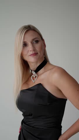 Woman in elegant black dress with jewelry. Young blonde concept.