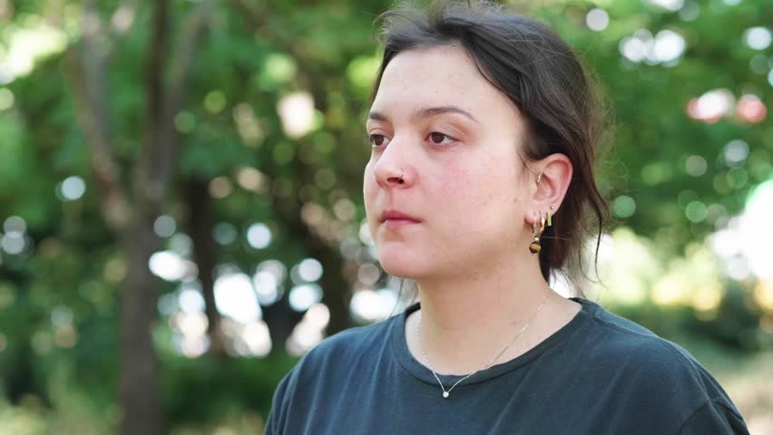 Young woman yawning in park

