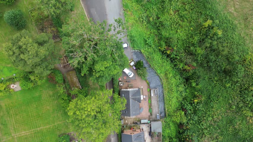 Drone shots of a flour mill with water wheel next to a train viaduct. Approaching, overhead flyover and wide shots. Pre Industrial revolution.