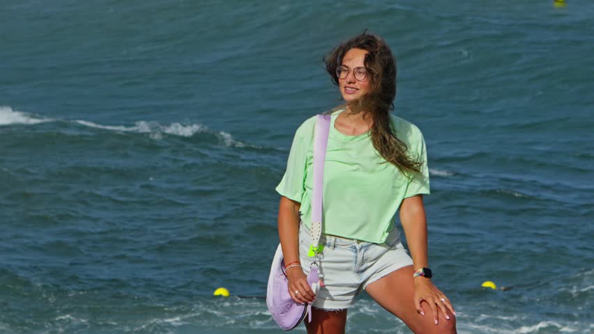 Woman standing on beach next to ocean