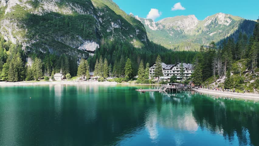 Lake Braies from a drone, people are sailing on boats
