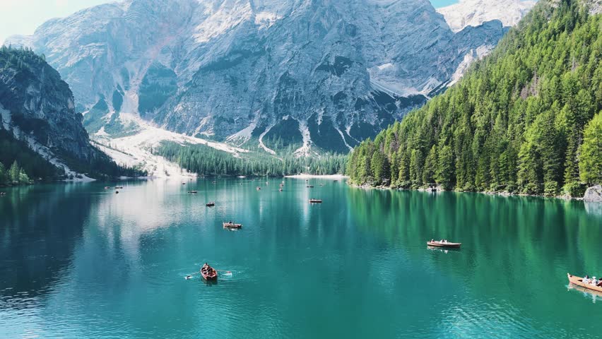 Lake Braies from a drone, people are sailing on boats