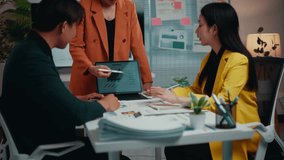 Businesswoman standing in a meeting room presents marketing data on a tablet to colleagues. Engaged team members listen attentively during the informative session - Powered by Shutterstock - Get 15% off with code: PIKWIZARD15