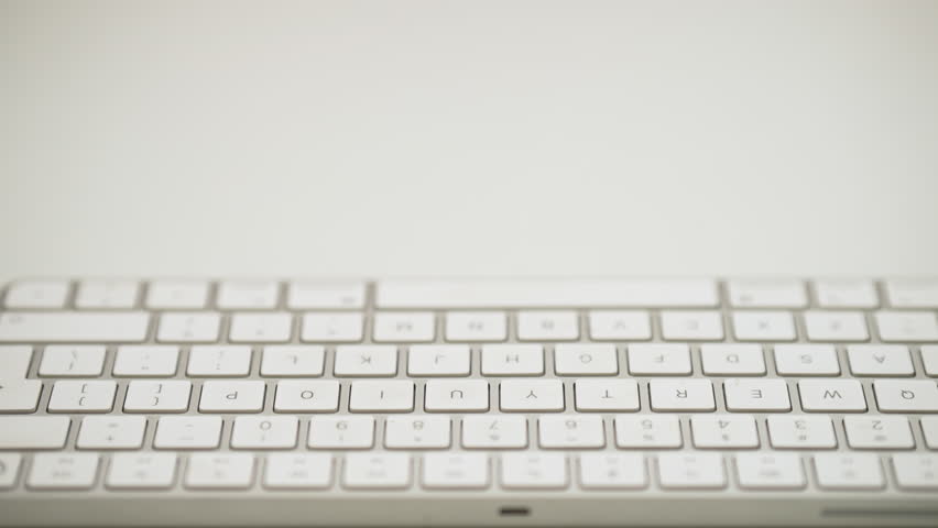Close-up of hands typing quickly on a computer keyboard, with fast-paced motion.
