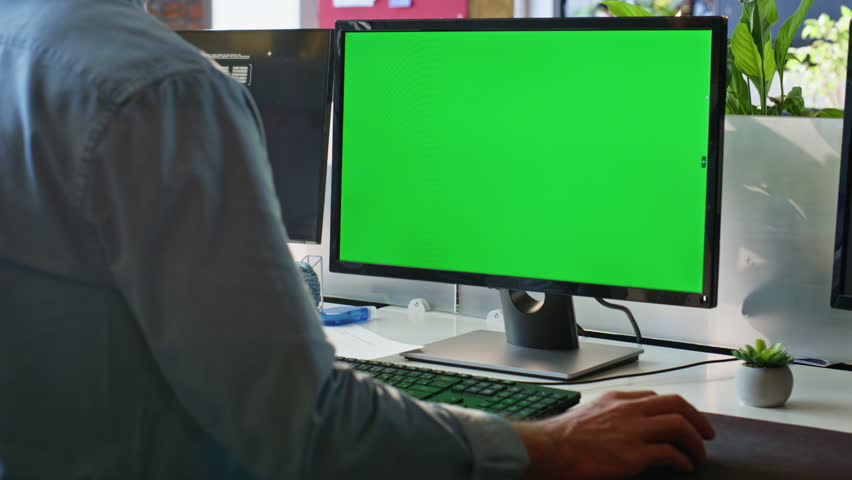Unknown freelancer working green screen computer in modern workplace closeup. Unrecognizable businessman looking chroma key desktop monitor surfing internet. Office worker browsing website mockup pc