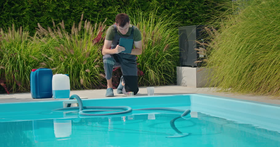 A worker determines the necessary amount of chlorine and pours it into the pool, using a tablet for home pool maintenance.