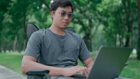 Businessman use smartphone and laptop sit on a chair in a park, Programmer hand hold smartphone conversation with abroad client distance meeting and typing on a laptop, Working online. - Powered by Shutterstock - Get 15% off with code: PIKWIZARD15