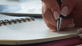 Woman hands writing notebook holding black ballpen closeup. Unknown businesswoman working modern office making notes in notepad at desk. Unrecognizable accountant noting information on paper indoors - Powered by Shutterstock - Get 15% off with code: PIKWIZARD15