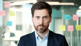 Webcam view. Confident male entrepreneur in professional attire listens to online meeting in modern office. Worker is studying online, listening remotely to a course, conference or seminar. Close up - Powered by Shutterstock - Get 15% off with code: PIKWIZARD15