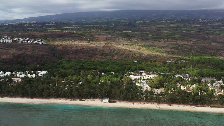 Aerial view of moody beach with waves and clouds, Plage des Brisants, Saint-Gilles-Les-Bains, Reunion.