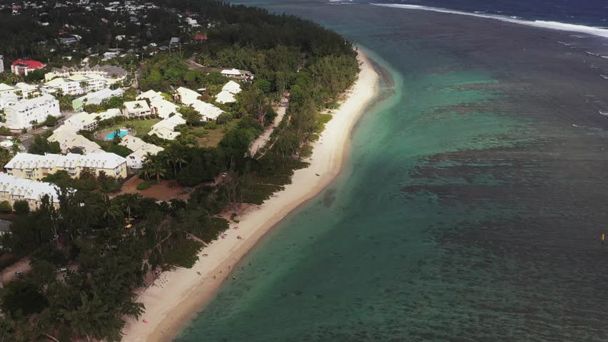 Aerial view of moody Plage des Brisants beach with waves and clouds, Saint-Gilles-Les-Bains, Reunion.