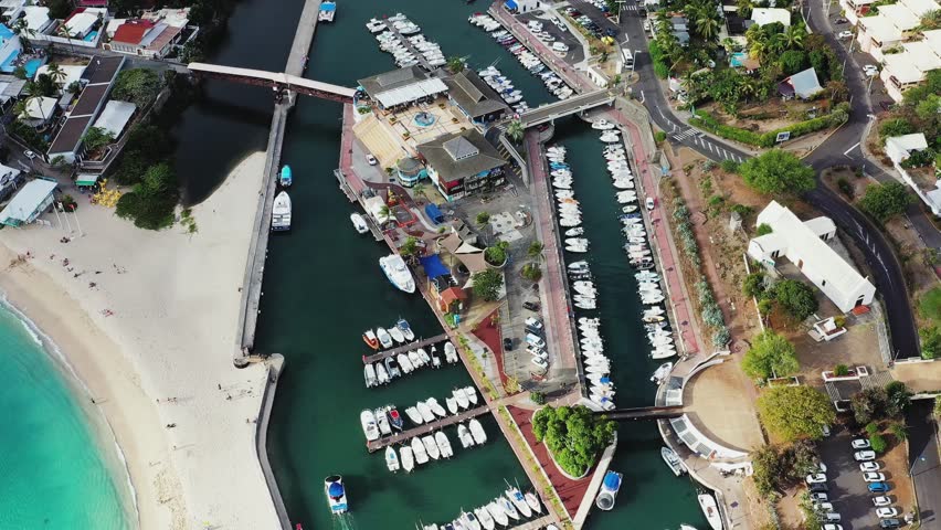 Aerial view of the beautiful harbour and marina with boats near Plage des Roches Noires and the church Paroisse Notre-Dame-de-la-Paix, Saint-Gilles-Les-Bains, Reunion.
