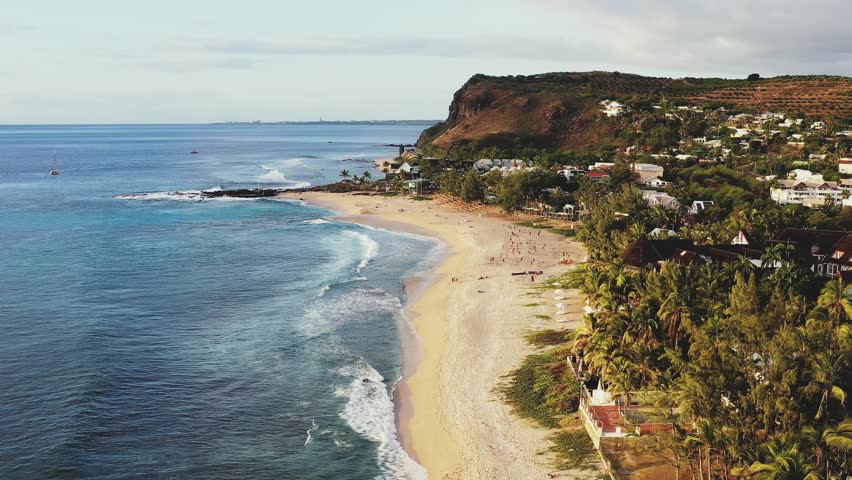 Aerial view of Plage de Boucan Canot with sandy beach, moody natural pool, and sailing boats, Saint-Gilles-Les-Bains, Reunion.
