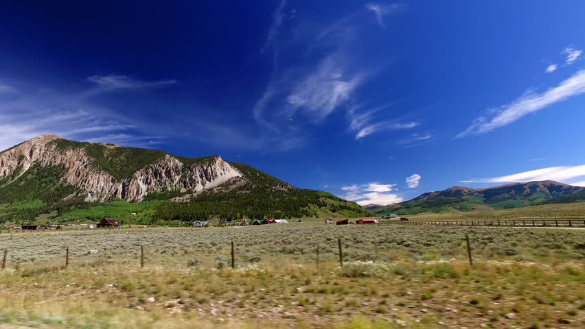 Point Of View Small Houses In Field By Green Mountains On Sunny Day - Crested Butte, Colorado