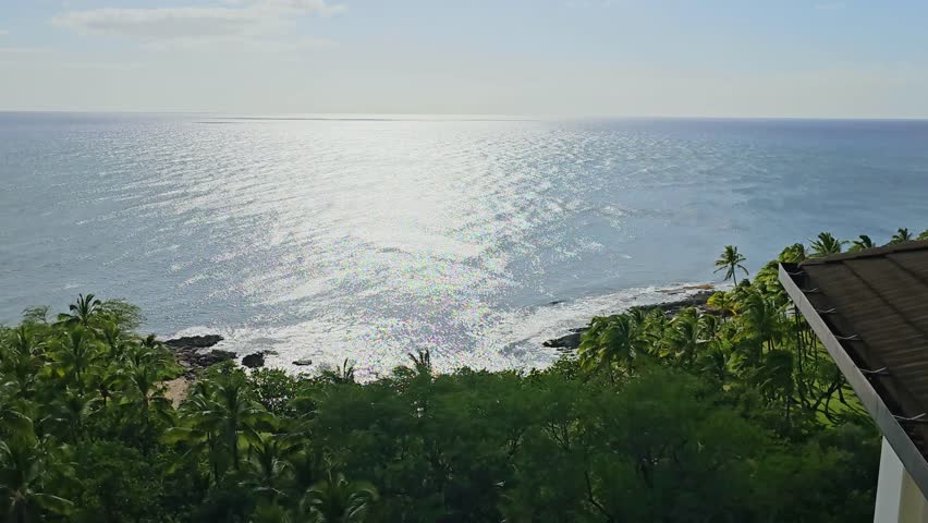 footage of the Pacific ocean at sunset with waves, lush green trees, plants and grass, blue sky and clouds on the island of Oahu at the Ko Olina Resort in Kapolei Hawaii USA