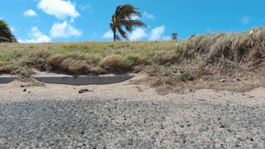 ascending aerial footage of the pacific ocean with waves crashing into the rocks on the sandy beach, blue sky and clouds at Sandy Beach in Honolulu Hawaii USA